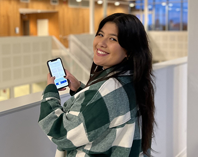 Picture of Johanna Ladi, Business Developer at MEKO with a smartphone in her hands.